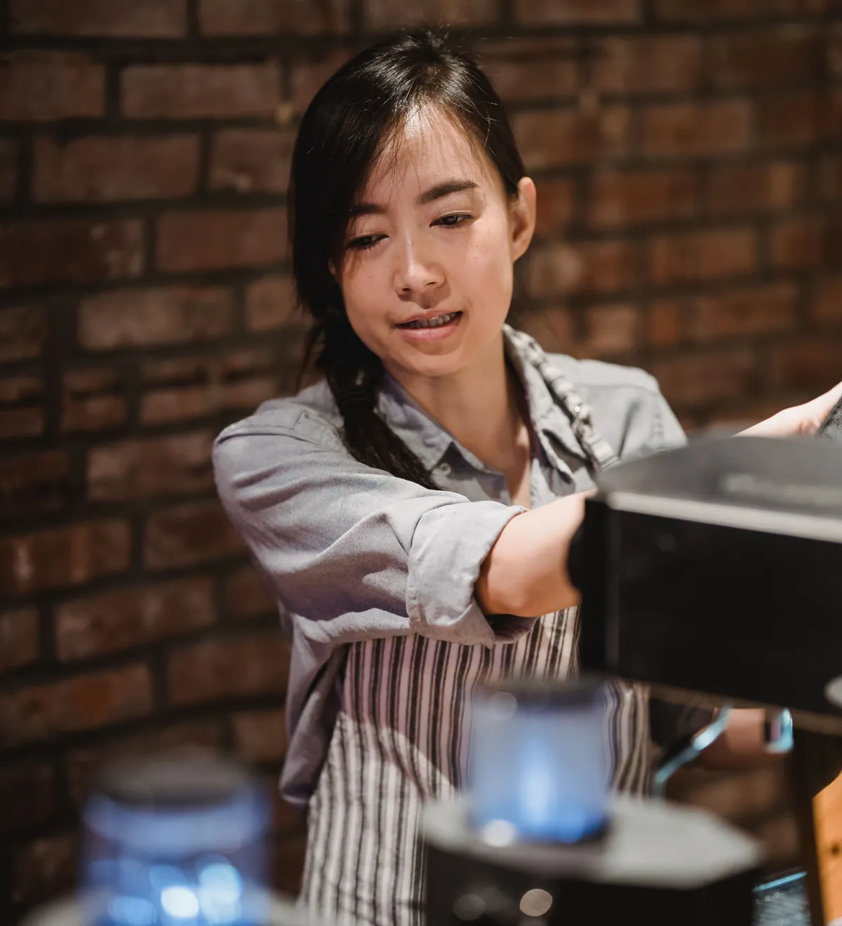 Barista operating a coffee machine in a small cafe